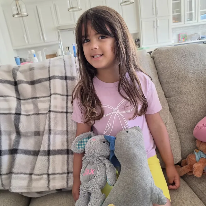 A real photo of a girl with her stuffed animals
